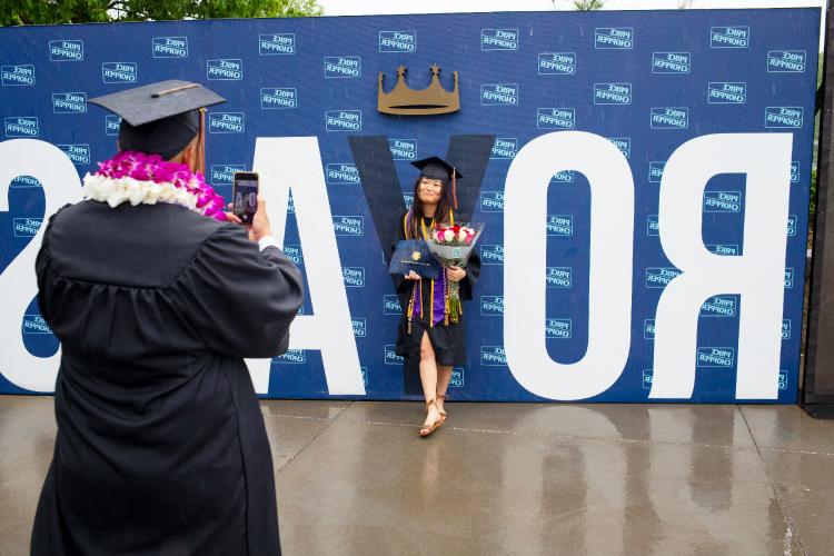 Female grad in front of Royals sign