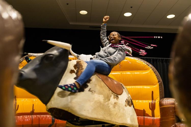 A student rides a bull at Late Night with the Greeks