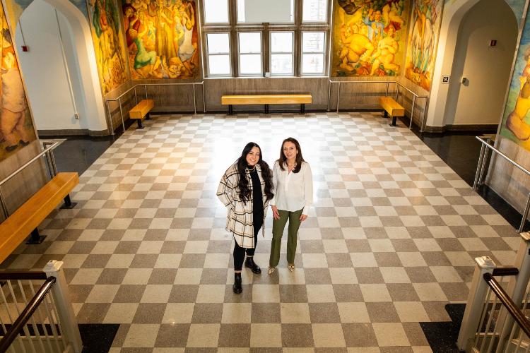 维多利亚 and Viviana in the checkered floor lobby surrounded by the murals