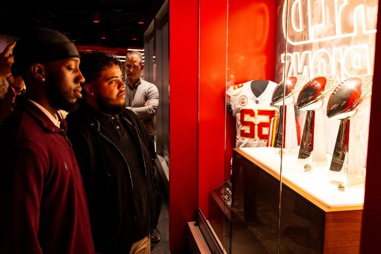 UMKC Students participating in the stadium tour during their shadow day and viewing all three of the Super Bowl Vince Lombardi Trophies through the glass at arrowhead stadium