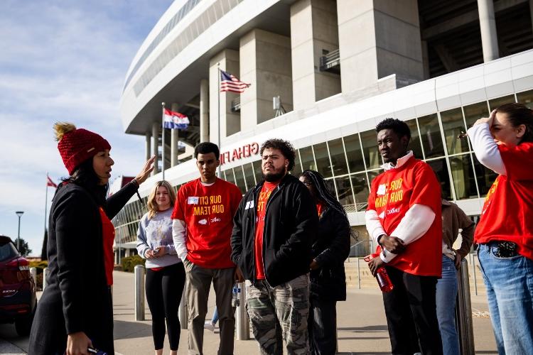 UMKC students standing in front of  Arrowhead stadium listening to the instructor and getting ready for the stadium tour