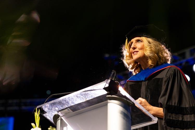 Leigh Anne Taylor Knight speaks at a podium at Commencement